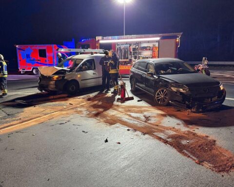 Feuerwehr im Einsatz nach Verkehrsunfall mit zwei Pkw im Autobahnkreuz, gesperrte Straße.