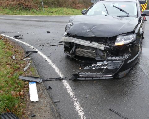 Zwei beschädigte Autos nach Unfall, Polizei und Rettungskräfte sichern die Unfallstelle.
