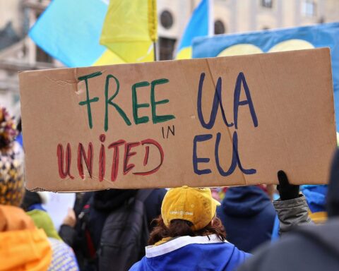 Pro-Ukraine-Demo mit Flaggen und Menschen, die Solidarität und Unterstützung für die Ukraine zeigen.