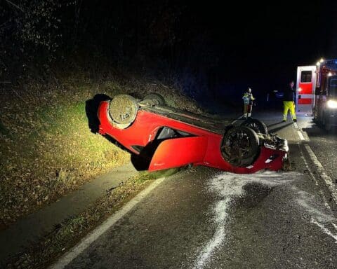 Überschlagener Toyota auf Dach, Unfallort mit Polizei und Rettungswagen. Winterliche Glätte.