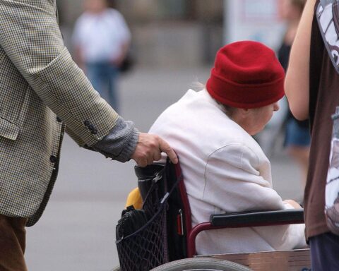 Seniorin im Rollstuhl symbolisiert die Herausforderungen der gesetzlichen Pflegeversicherung und den Reformbedarf.