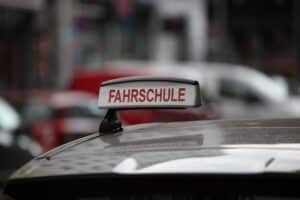 Fahrschüler lernen in einem Klassenzimmer, Fahrschule, Verkehrszeichen, digitale Lernmethoden, Prüfungen.