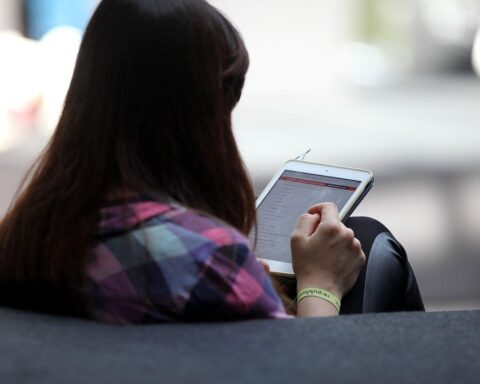 Frau mit Tablet diskutiert über Klarnamenpflicht und Netzsicherheit in sozialen Medien.