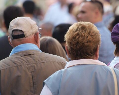 Senioren in Fußgängerzone diskutieren über Renteneintrittsalter und soziale Sicherheit.