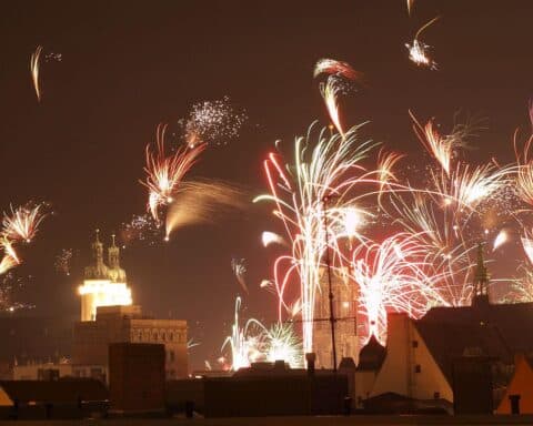 Blick auf ein buntes Silvesterfeuerwerk über der Regnitz in Bamberg, feierliche Atmosphäre.