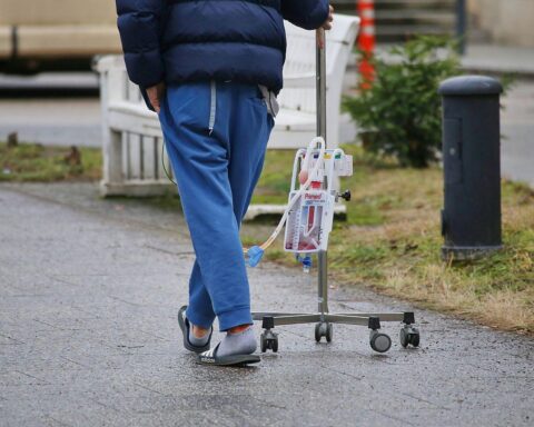 Patient mit Infusionsständer symbolisiert steigende Gesundheitskosten und Herausforderungen im deutschen Gesundheitssystem.