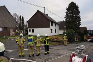 Feuerwehr löscht Brand in Wohnhaus, Bewohner evakuiert, Katze erfolgreich gerettet.