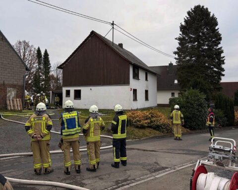 Feuerwehr löscht Brand in Wohnhaus, Bewohner evakuiert, Katze erfolgreich gerettet.