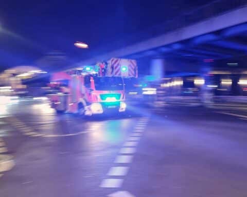 Einsatzkräfte der Feuerwehr löschen Brand in Wohnhaus, Bewohner evakuieren sich unverletzt.