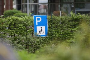 Braille-Sprache auf einem Parkplatzschild, symbolisiert Zugänglichkeit für Menschen mit Behinderungen.
