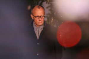 Friedrich Merz steht vor einem Weihnachtsbaum und plant ruhige Feiertage im Sauerland.