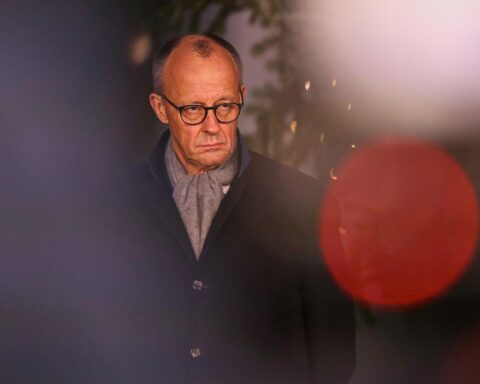 Friedrich Merz steht vor einem Weihnachtsbaum und plant ruhige Feiertage im Sauerland.