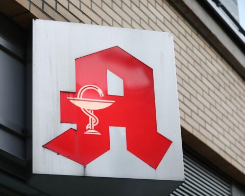 Logo einer Apotheke vor einem Hintergrund, der ländliche Gesundheitsversorgung symbolisiert.