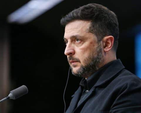 Wolodymyr Selenskyj steht im Mittelpunkt, umgeben von Symbolen für Verhandlungen und Korruption.