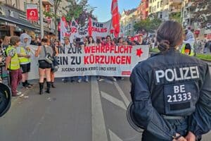 Menschen demonstrieren gegen Rückkehr der Wehrpflicht, Transparente und Plakate sichtbar, in Berlin.