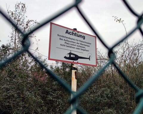 Bergrettung: Hubschrauber landet auf Fläche, warnende Botschaft über Verantwortung und Sicherheit in den Alpen.