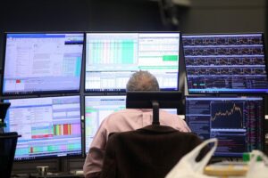 Frankfurter Börse mit Dax-Diagramm, positive Handelslage, Edelmetalle im Fokus, wirtschaftliche Trends sichtbar.