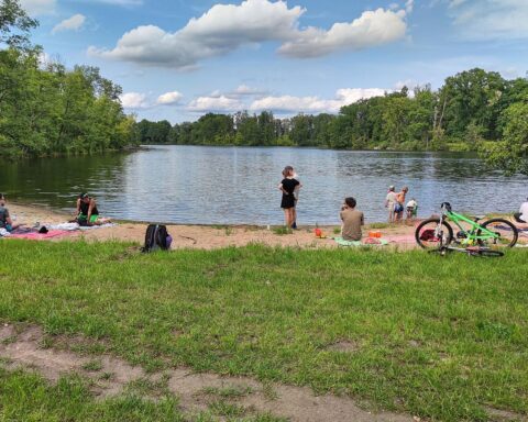 Sonniger Badestrand mit wenigen Besuchern, symbolisiert die Wärme und Trockenheit 2025 in Deutschland.