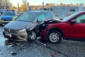Unfallstelle mit beschädigten Fahrzeugen, Polizeiautos und Feuerwehr im Einsatz. Verletzte werden behandelt.