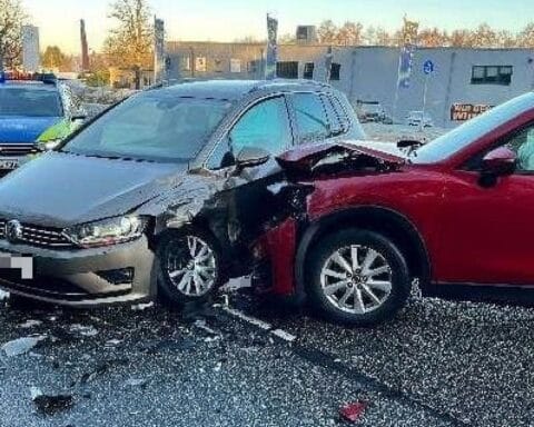 Unfallstelle mit beschädigten Fahrzeugen, Polizeiautos und Feuerwehr im Einsatz. Verletzte werden behandelt.