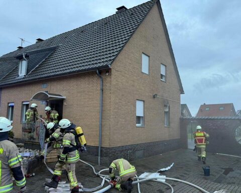 Bild zeigt Feuerwehr bei Einsatz, Küchenbrand in Wohnhaus, Brandort mit Einsatzfahrzeugen und Feuerwehrleuten.