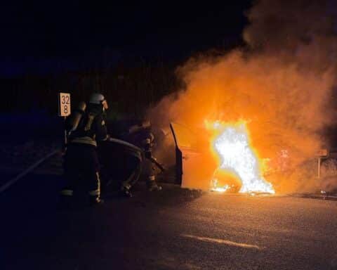 Brand eines Pkw, Feuerwehr im Einsatz, Nachtaufnahme, Flammen und Rauch sichtbar.