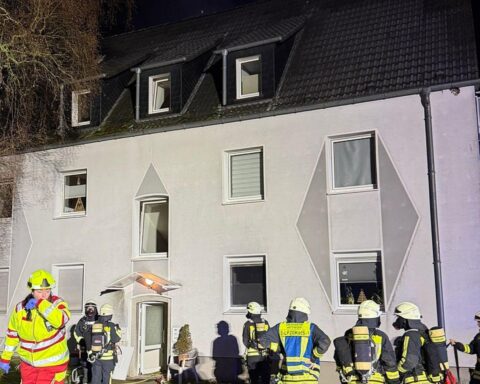 Feuerwehr rettet Bewohner aus brennender Dachgeschosswohnung, Flammen und Rauch sichtbar.