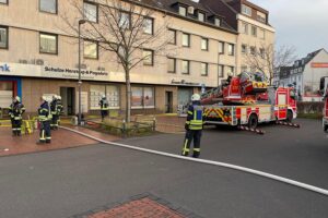 Feuerwehr im Einsatz, evakuierte Bewohner, Rauchentwicklung nach Zimmerbrand in Dinslaken.