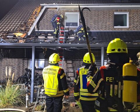 Feuerwehr löscht Brand an Doppelhaus, Einsatzkräfte mit Fahrzeugen und Drehleiter im Einsatz.