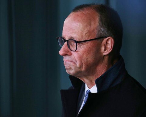 Friedrich Merz, von Sorgen gezeichnet, umringt von Nachrichtenberichten zur politischen Stimmung in Deutschland.