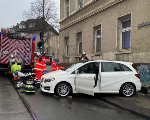 Blick auf Einsatzstelle: Polizei, Feuerwehr und verletzte Fußgängerin nach Unfall in Essen.