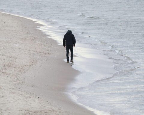 Mann am Strand, nachdenklich, symbolisiert die Einsamkeit in unserer modernen Gesellschaft.