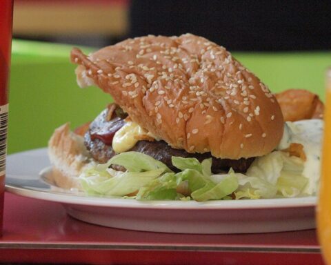 Ein Burger auf einem Teller, symbolisiert die Gastronomie und die Mehrwertsteuer-Debatte in Deutschland.