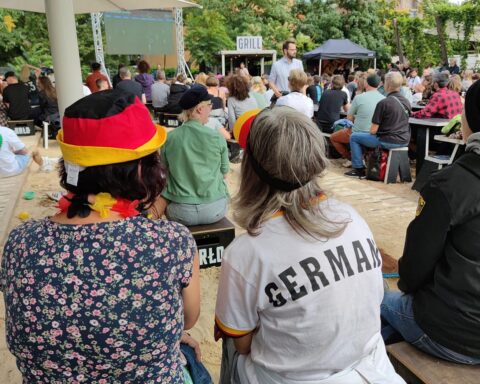 Biergarten mit Zuschauern, die gemeinsam Frauenfußball bei EM 2029 genießen und feiern.