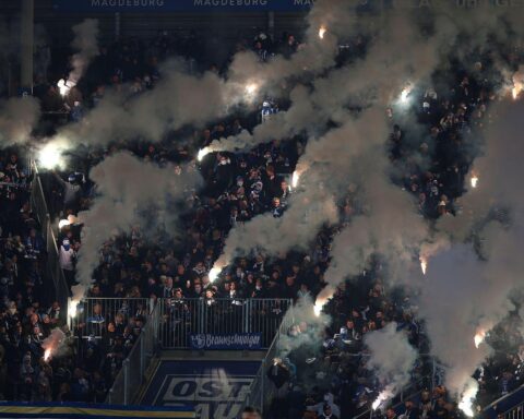 Fans mit Pyrotechnik feiern gemeinsam im Stadion und zeigen ihre Leidenschaft für Fußball.