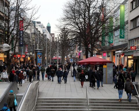 Menschen mit italienischer Einwanderungsgeschichte in deutscher Fußgängerzone, Vielfalt und kulturelle Integration sichtbar.