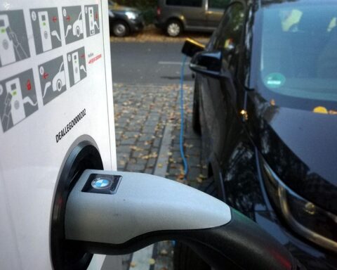 Elektroauto an Ladestation, Symbol für E-Mobilitätsprämie und Unterstützung gebrauchter Fahrzeuge.