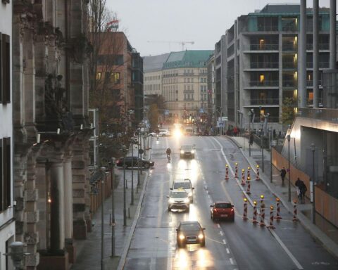 Zwei Gruppen von Personen im virtuellen Straßenverkehr, die Fahrzeugankünfte einschätzen.