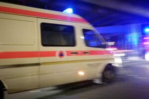 Krankenwagen vor Mehrfamilienhaus, Einsatzkräfte nach Wohnungsbrand, trauriger Vorfall mit Todesopfer.