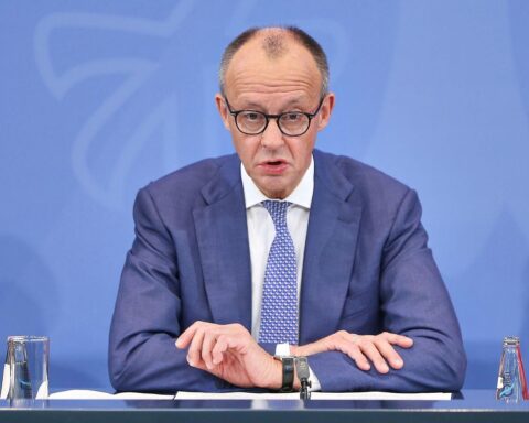Friedrich Merz in Anzug, während Neujahrsansprache, symbolisiert Hoffnung und Reformwillen Deutschlands.