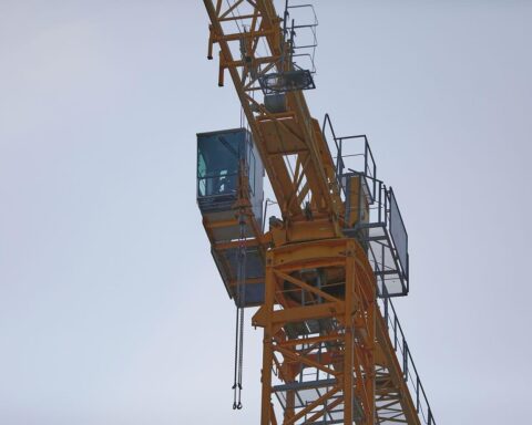 Baukran über Baustelle der Zeller Talbrücke, umgeben von ländlicher Landschaft im Odenwald.