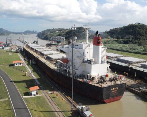 Frachtschiff im Panama-Kanal symbolisiert globalen Handel und wirtschaftliche Herausforderungen.