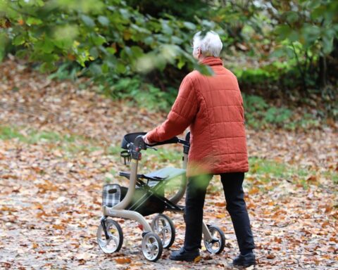 Seniorin betrachtet kritisch Rentenpolitik, symbolisiert Sorgen um soziale Sicherheit und Zukunftsperspektiven.