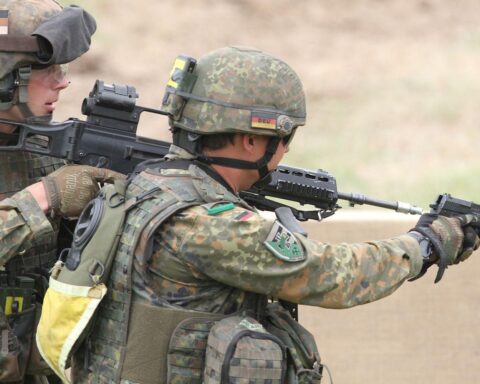 Bundeswehr-Soldat mit Pistole, symbolisiert Sicherheit und Militärpräsenz in der Ukraine-Debatte.