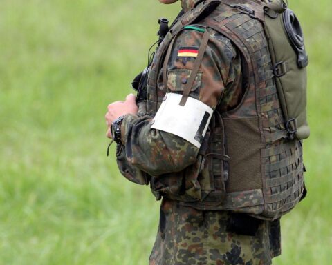 Bundeswehr-Soldat mit ernster Miene, Hintergrund: Kaserne, Symbol für Aufklärung und Konsequenzen.