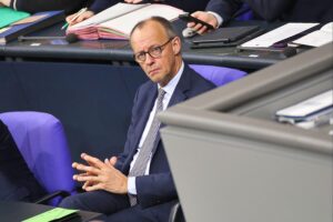 Friedrich Merz in Berlin, umgeben von politischen Symbolen, Diskussion über Rentenreform und soziale Gerechtigkeit.
