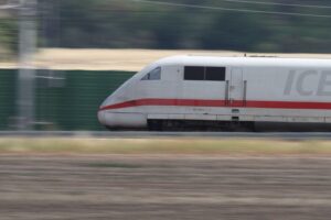 Ein ICE-Zug fährt auf einer modernen, generalsanierten Bahnstrecke, die digitale Technik symbolisiert.