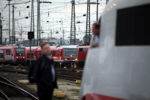 Lokführer im Gespräch am Gleis, symbolisieren Sicherheit und Zusammenarbeit im Bahnsektor.
