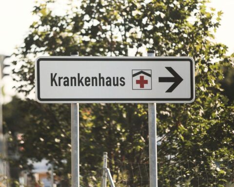 Ein schwerer Verkehrsunfall auf der Autobahn mit einem rettenden Krankenhaus im Hintergrund.