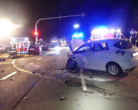 Zwei beschädigte Autos an Kreuzung, Polizei vor Ort, Verletzte werden behandelt.